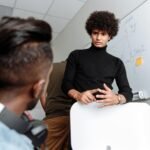 A group of young professionals discussing ideas during an office meeting around a whiteboard.